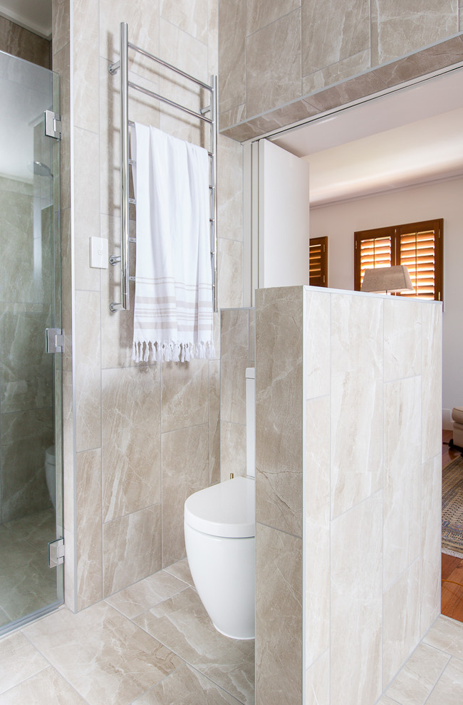 Inspiration for a large contemporary master bathroom in Brisbane with dark wood cabinets, a freestanding tub, an alcove shower, beige tile, porcelain tile, porcelain floors, engineered quartz benchtops, beige floor and a hinged shower door.