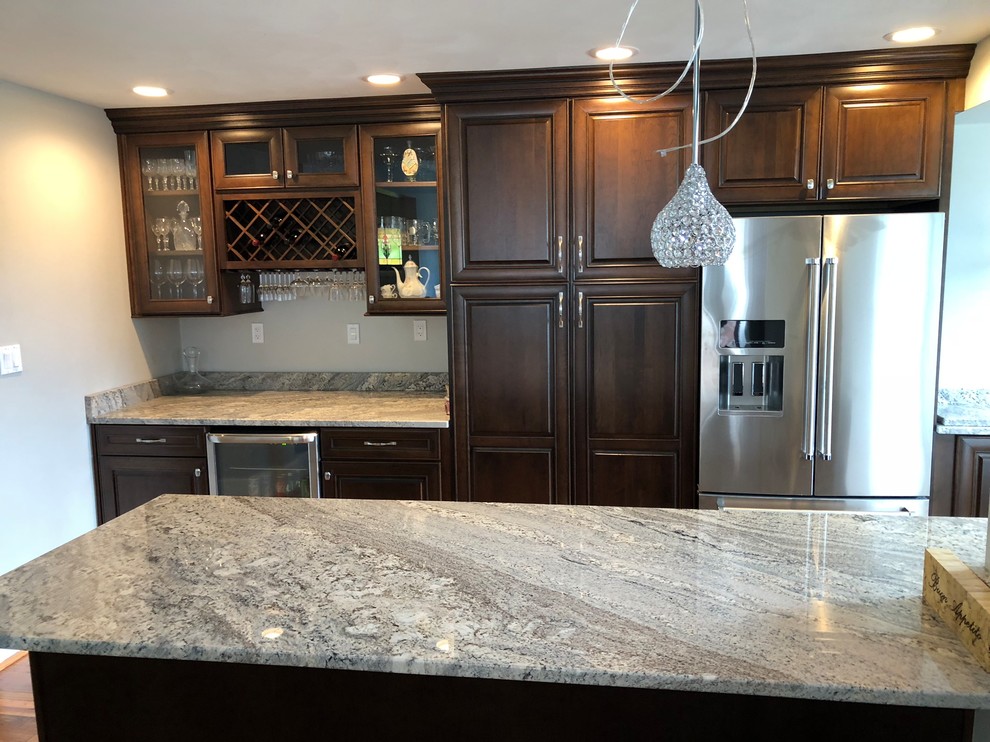 Inspiration for a mid-sized timeless l-shaped light wood floor and brown floor eat-in kitchen remodel with an undermount sink, raised-panel cabinets, dark wood cabinets, granite countertops, multicolored backsplash, ceramic backsplash, stainless steel appliances, an island and multicolored countertops