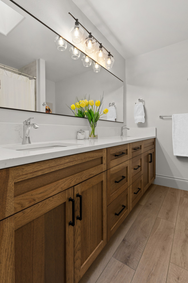 Design ideas for a transitional kids bathroom in Portland with shaker cabinets, medium wood cabinets, white walls, vinyl floors, an undermount sink, engineered quartz benchtops, white benchtops, a double vanity and a built-in vanity.