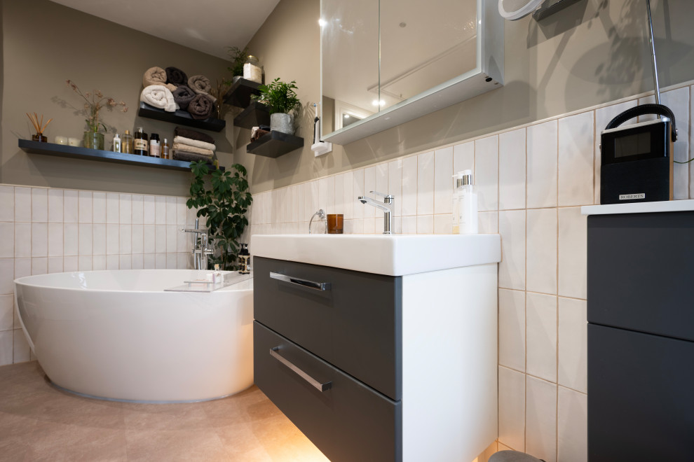Design ideas for a mid-sized contemporary kids bathroom in Kent with flat-panel cabinets, grey cabinets, a freestanding tub, a corner shower, a bidet, white tile, ceramic tile, green walls, a wall-mount sink, pink floor, a hinged shower door, a single vanity and a floating vanity.