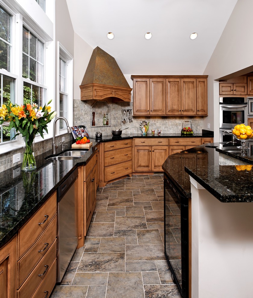 Inspiration for a traditional l-shaped kitchen in DC Metro with a double-bowl sink, raised-panel cabinets, medium wood cabinets, grey splashback and stainless steel appliances.
