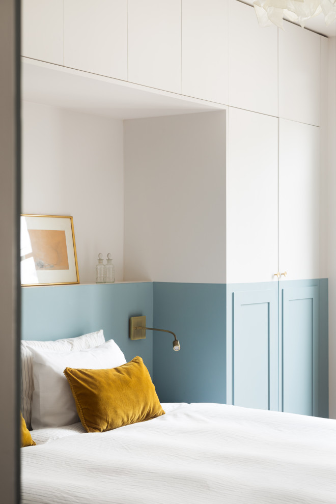 Inspiration pour une chambre parentale minimaliste de taille moyenne avec un mur bleu, parquet clair et dressing.