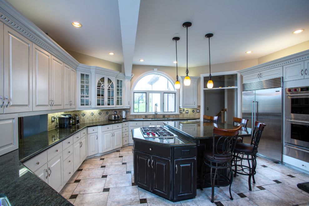 Huge transitional u-shaped ceramic tile and beige floor eat-in kitchen photo in Chicago with a drop-in sink, raised-panel cabinets, white cabinets, limestone countertops, beige backsplash, ceramic backsplash, stainless steel appliances and an island