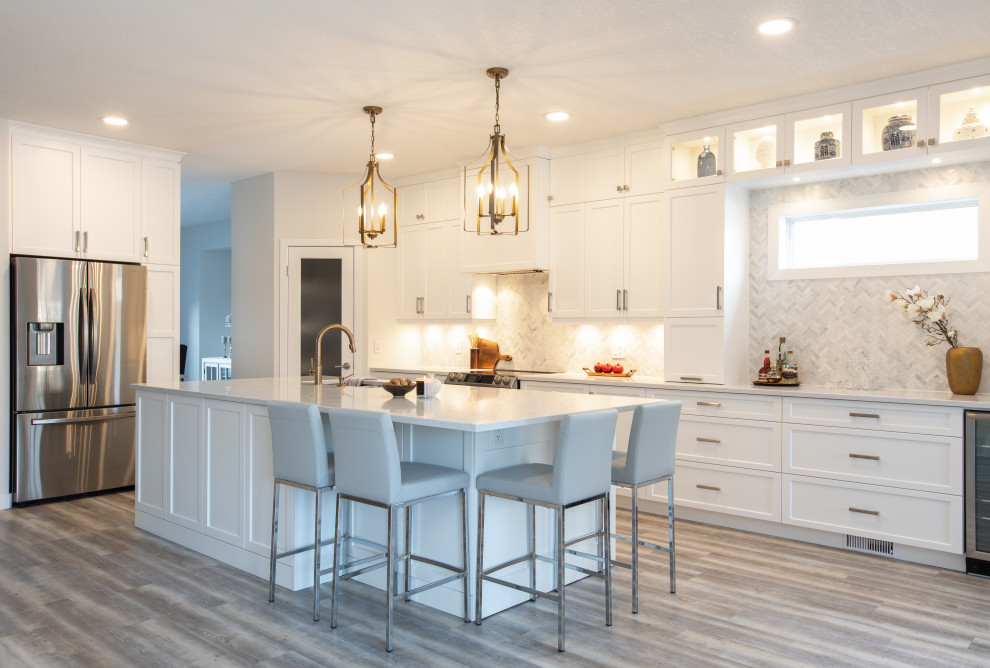 Open concept kitchen - large transitional l-shaped vinyl floor and gray floor open concept kitchen idea with an undermount sink, shaker cabinets, white cabinets, quartz countertops, white backsplash, marble backsplash, stainless steel appliances, an island and white countertops