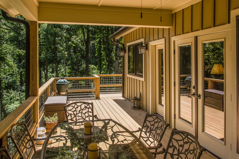 Example of a mid-sized transitional backyard deck design with decking and a roof extension