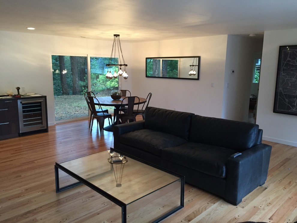 Photo of a midcentury open concept living room in Portland with white walls and medium hardwood floors.