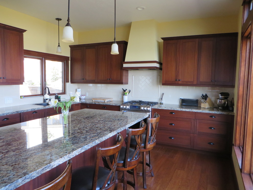 Mid-sized arts and crafts l-shaped kitchen in Orange County with an undermount sink, shaker cabinets, medium wood cabinets, granite benchtops, white splashback, subway tile splashback, stainless steel appliances, medium hardwood floors and with island.