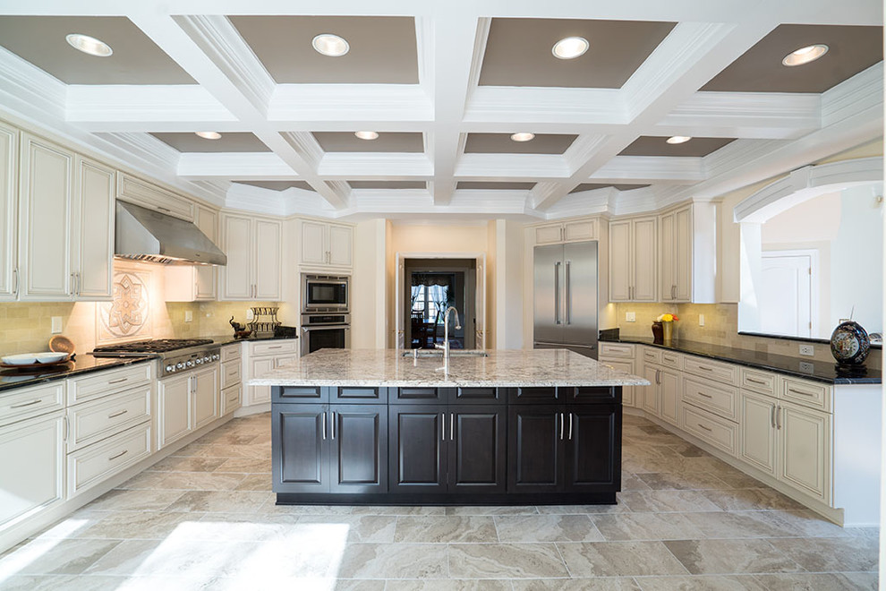 Photo of a large mediterranean u-shaped kitchen in DC Metro with raised-panel cabinets, beige cabinets, marble benchtops, beige splashback, stone tile splashback, stainless steel appliances, marble floors, with island and beige floor.