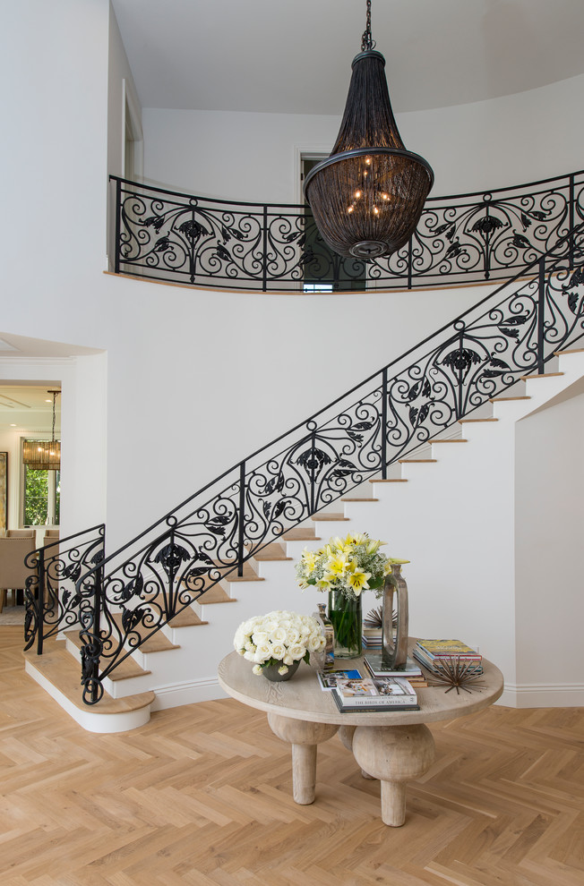 Example of a transitional wooden curved open and metal railing staircase design