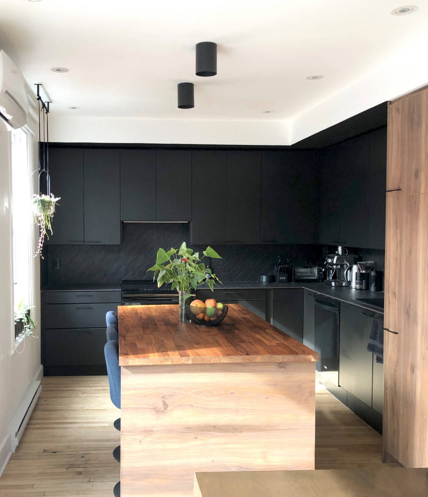 Esempio di un cucina con isola centrale minimalista di medie dimensioni con ante lisce, ante nere, top in quarzo composito, paraspruzzi nero, paraspruzzi con piastrelle in ceramica, parquet chiaro e top nero