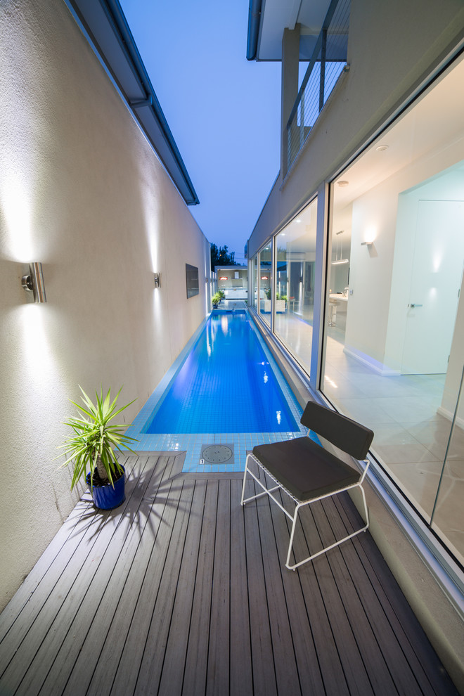 This is an example of a mid-sized modern side yard rectangular lap pool in Melbourne with decking.