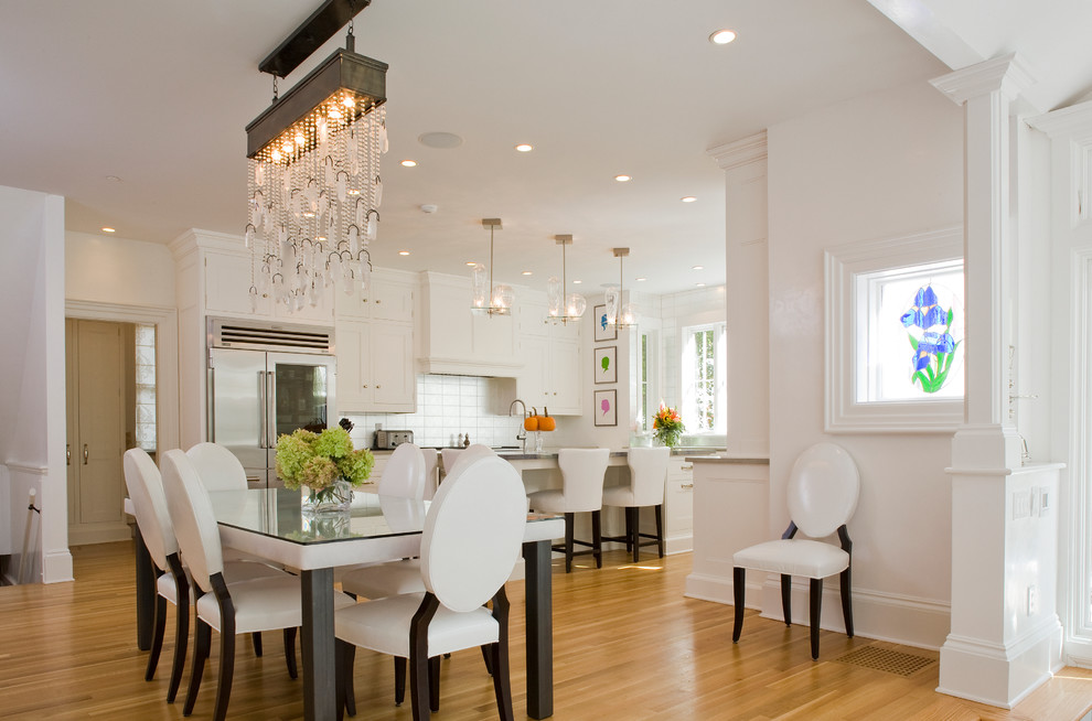 This is an example of a large traditional open plan dining in New York with white walls, medium hardwood floors and no fireplace.