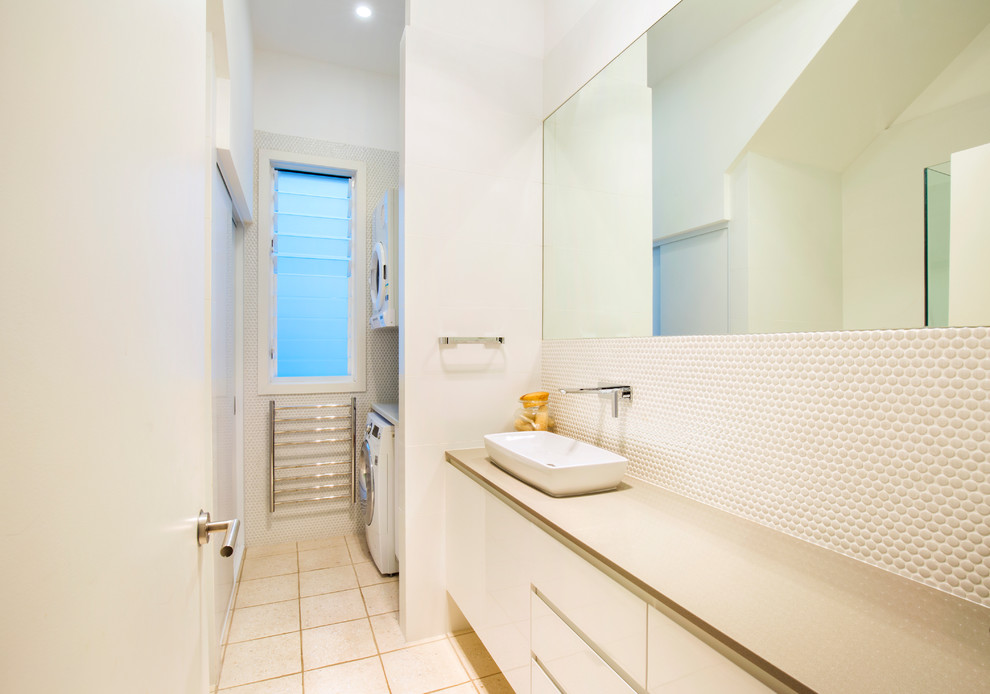 Design ideas for a mid-sized beach style bathroom in Sydney with flat-panel cabinets, white cabinets, engineered quartz benchtops, white walls, ceramic floors and a laundry.