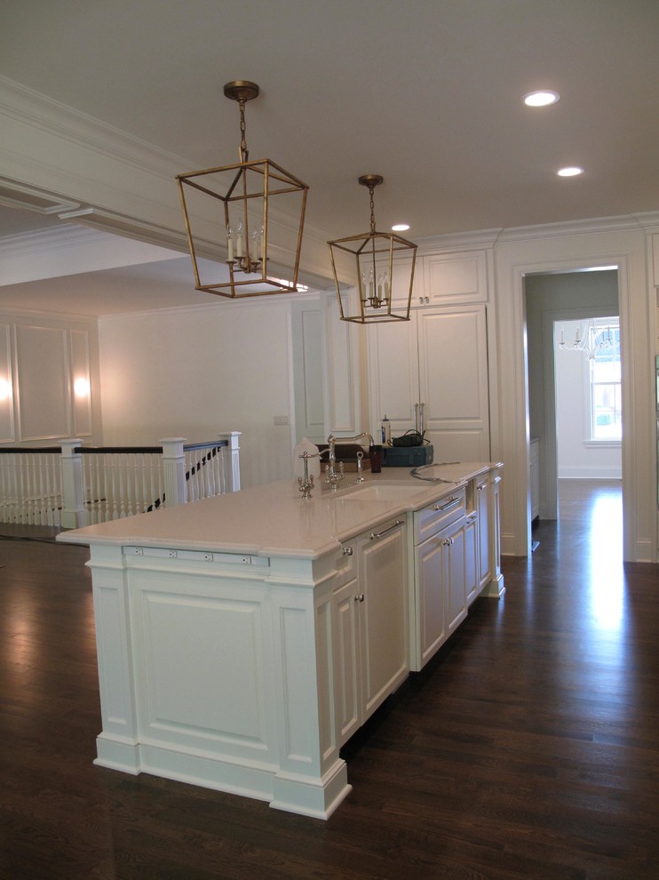 Inspiration for a large transitional u-shaped kitchen pantry remodel in Minneapolis with raised-panel cabinets, solid surface countertops, gray backsplash, stone slab backsplash, stainless steel appliances and an island