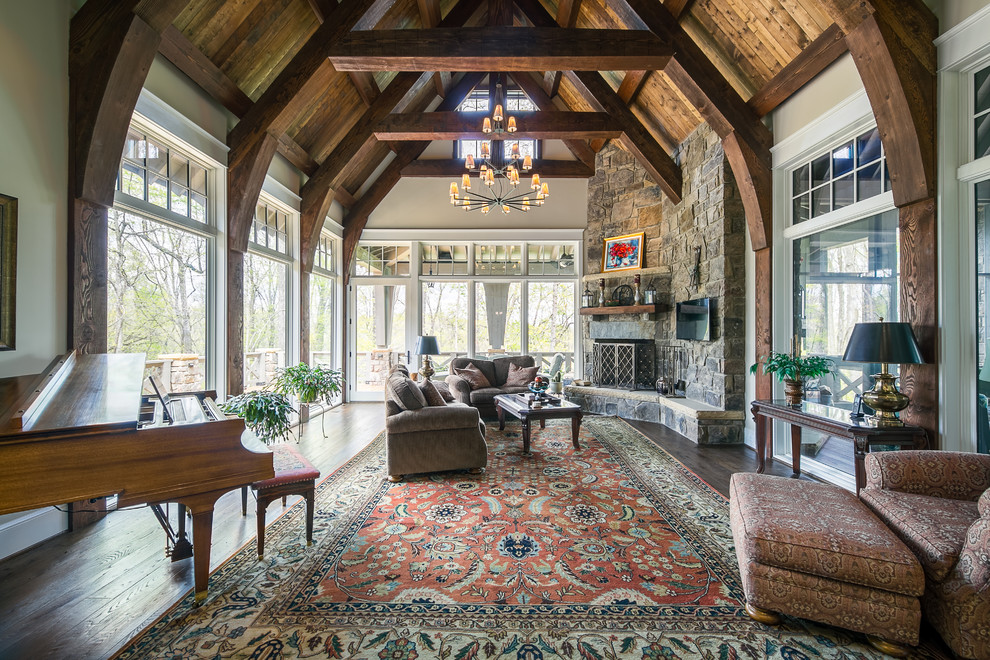 Design ideas for a country living room in Nashville with white walls, dark hardwood floors, a corner fireplace, a stone fireplace surround, a wall-mounted tv and brown floor.