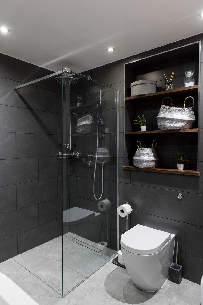 Design ideas for a large modern bathroom in London with raised-panel cabinets, dark wood cabinets, a freestanding tub, a shower/bathtub combo, a one-piece toilet, gray tile, cement tile, grey walls, ceramic floors, a pedestal sink and wood benchtops.