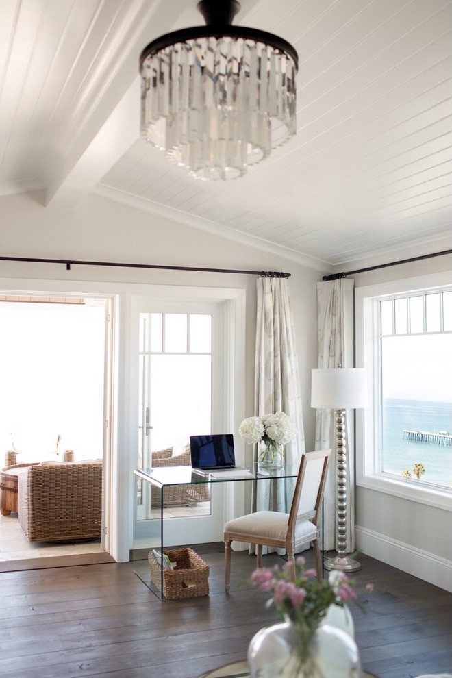 This is an example of a beach style home office in Orange County with white walls and a freestanding desk.
