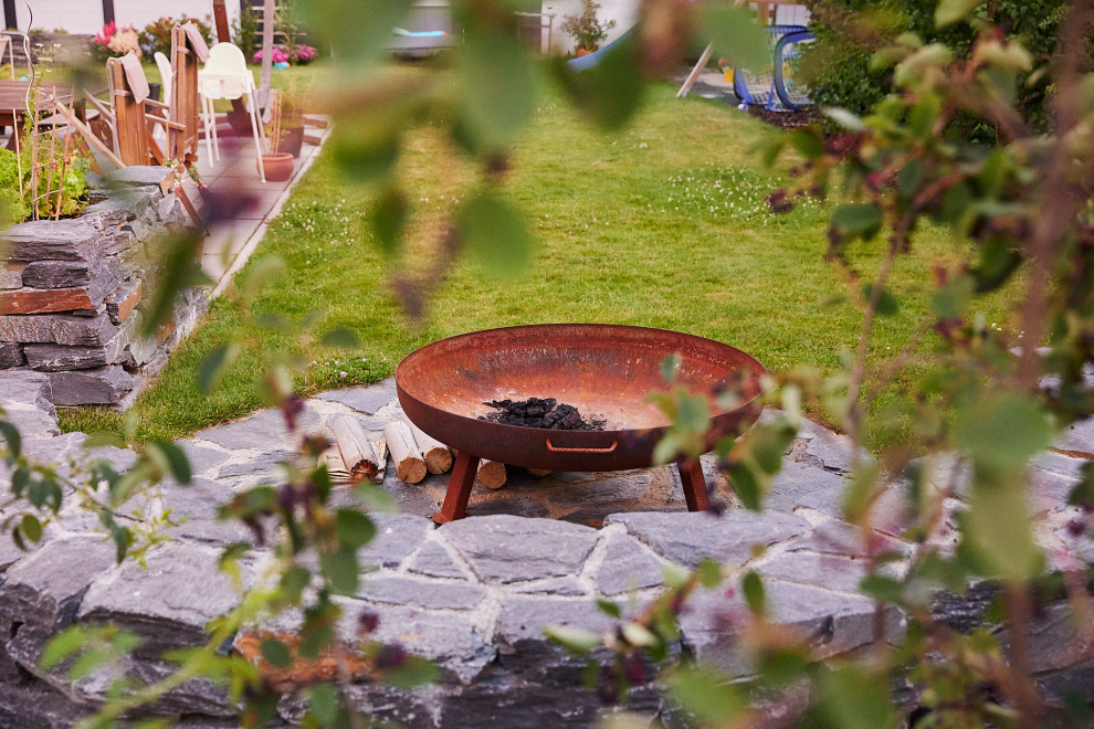 На фото: солнечный засухоустойчивый сад среднего размера на заднем дворе в стиле рустика с местом для костра, хорошей освещенностью и покрытием из гравия с
