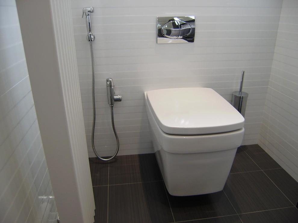 Small contemporary 3/4 bathroom in West Midlands with a wall-mount sink, flat-panel cabinets, grey cabinets, solid surface benchtops, a claw-foot tub, an alcove shower, a wall-mount toilet, white tile, porcelain tile, white walls and porcelain floors.