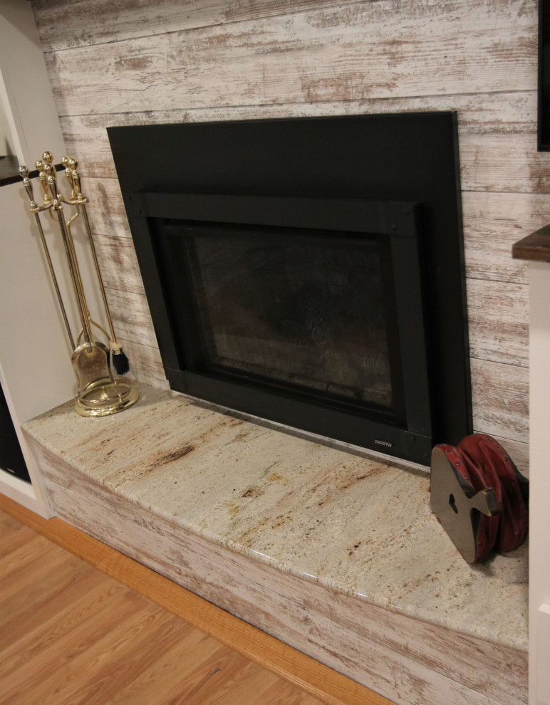 他の地域にある低価格の中くらいなラスティックスタイルのおしゃれなLDK (白い壁、淡色無垢フローリング、標準型暖炉、塗装板張りの暖炉まわり、据え置き型テレビ、マルチカラーの床) の写真
