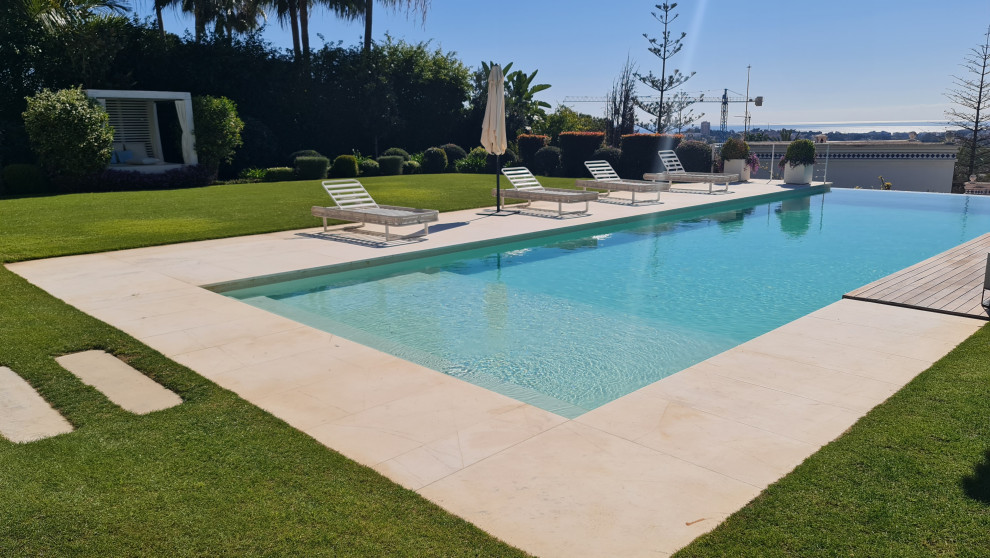 Idee per una grande piscina moderna personalizzata davanti casa con una dépendance a bordo piscina e graniglia di granito