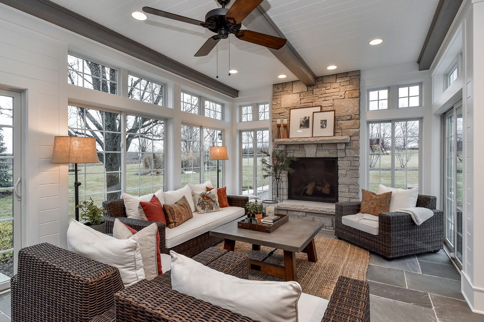 Inspiration for a country sunroom in Chicago with slate floors, a standard fireplace, a stone fireplace surround and a standard ceiling.