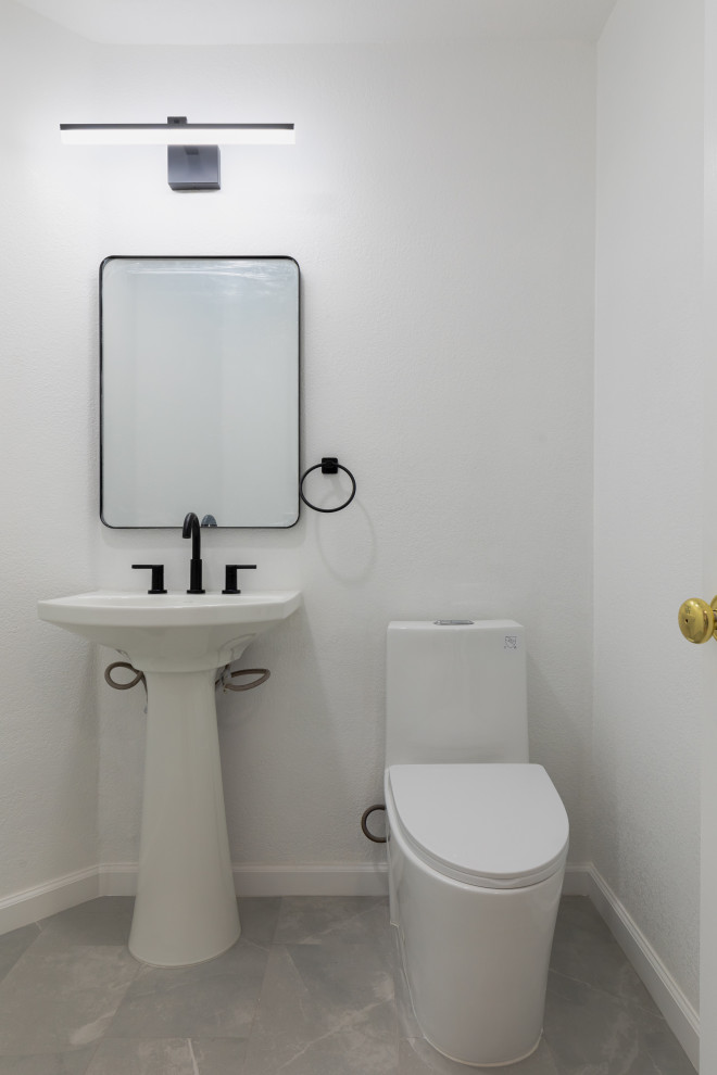 Foto de aseo minimalista pequeño con sanitario de una pieza, paredes blancas, suelo de baldosas de cerámica, lavabo sobreencimera, suelo gris y ladrillo