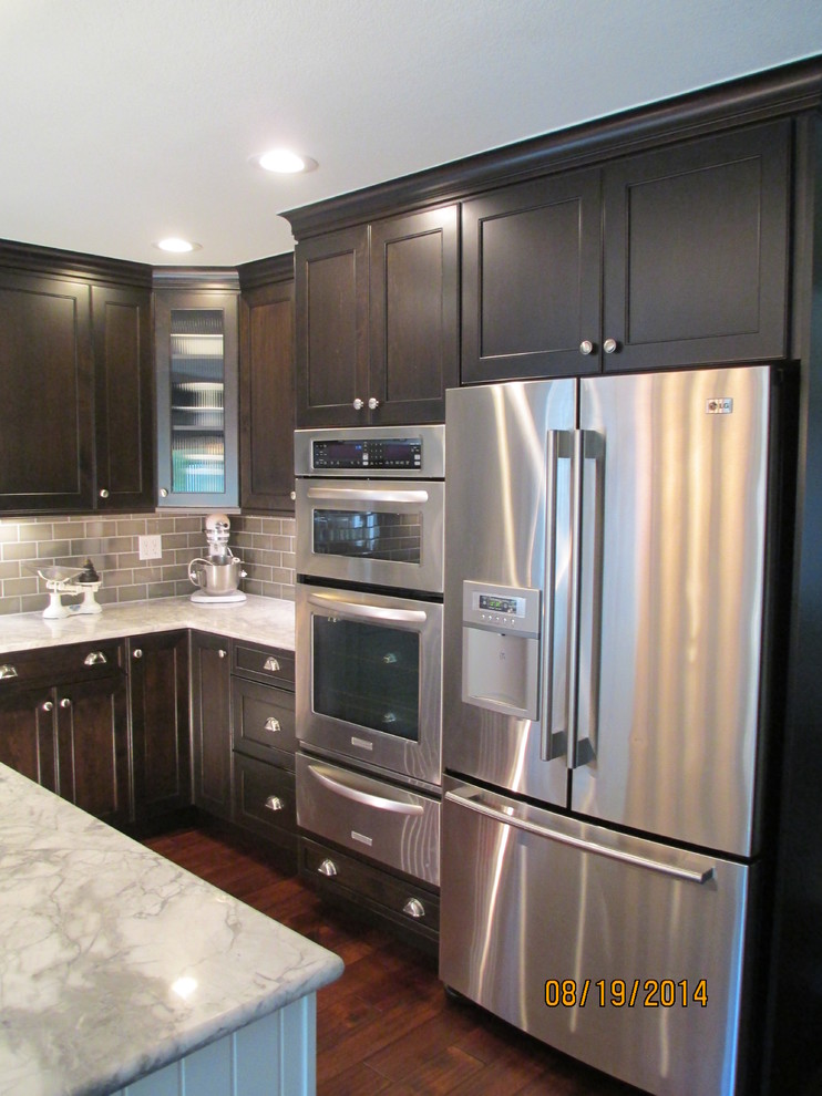 Inspiration for a mid-sized transitional u-shaped dark wood floor kitchen remodel in Denver with an undermount sink, shaker cabinets, dark wood cabinets, marble countertops, gray backsplash, subway tile backsplash, stainless steel appliances and an island