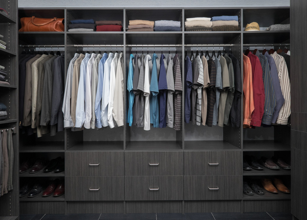 Inspiration for a large modern gender-neutral walk-in wardrobe in Salt Lake City with flat-panel cabinets, dark wood cabinets, porcelain floors and black floor.