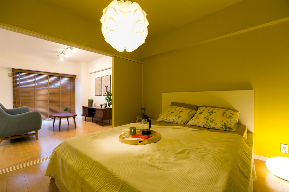 Scandinavian bedroom in Other with yellow walls, medium hardwood floors and brown floor.