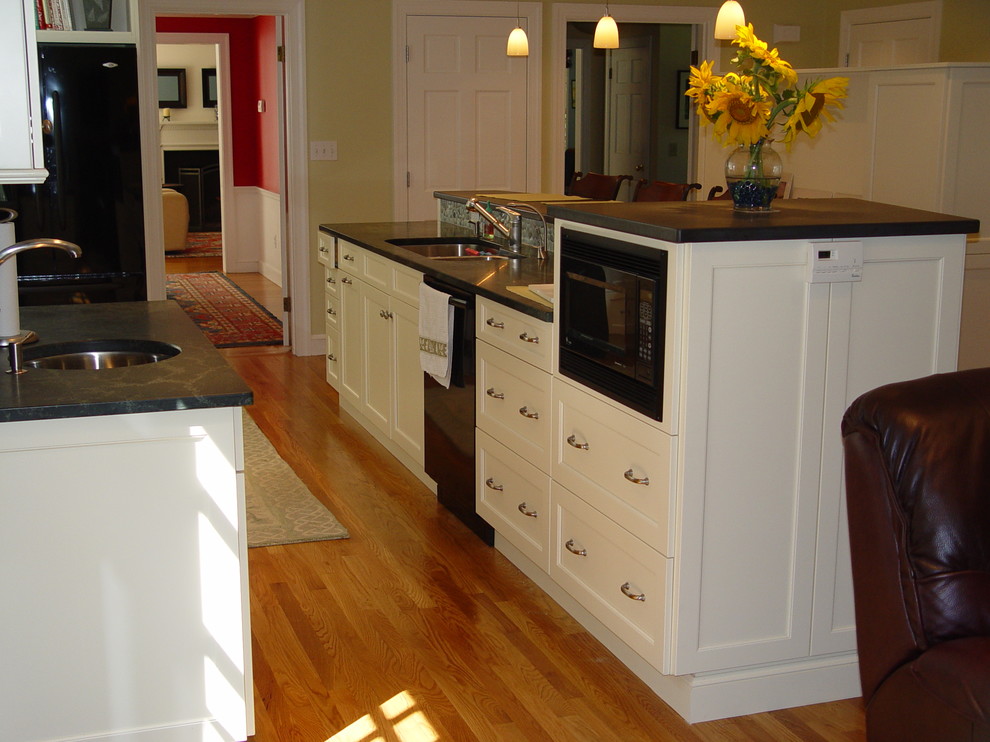 Kitchen - transitional kitchen idea in Boston with an undermount sink, recessed-panel cabinets, white cabinets, granite countertops, black appliances and an island