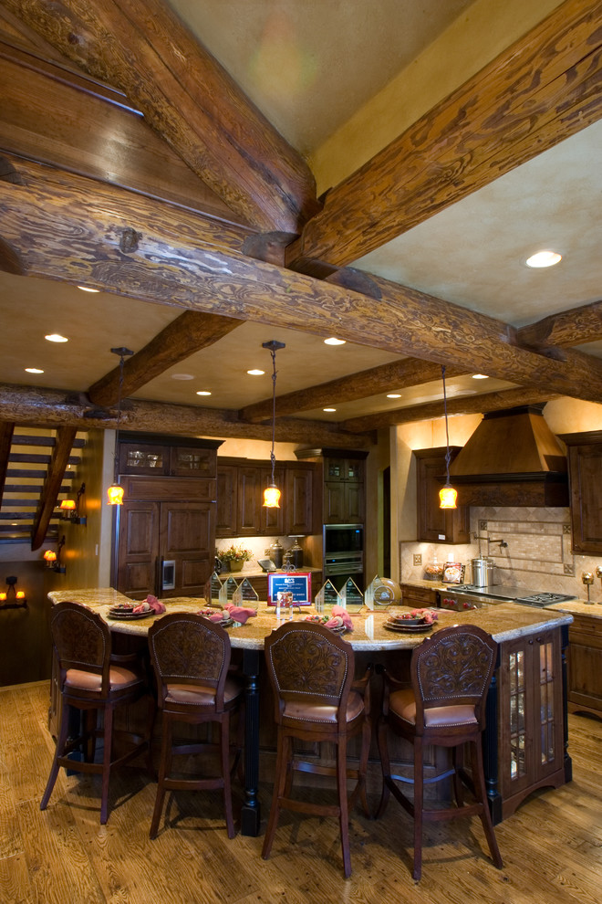 Kitchen - rustic l-shaped kitchen idea in Denver with dark wood cabinets, beige backsplash and paneled appliances
