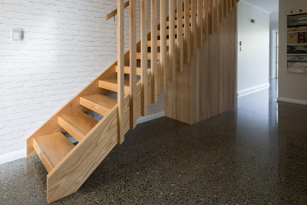 Bild på en mellanstor minimalistisk rak trappa i trä, med öppna sättsteg