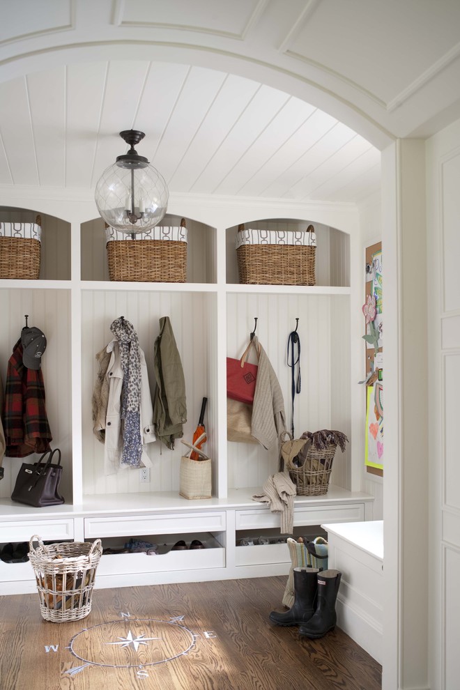 Photo of a mudroom in New York with white walls and dark hardwood floors.