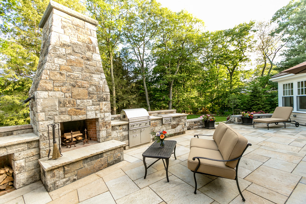 Inspiration for a large transitional backyard patio in Boston with natural stone pavers.