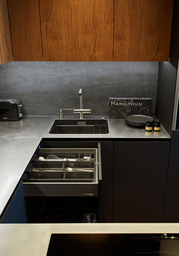 Mid-sized u-shaped open plan kitchen in Moscow with a single-bowl sink, black cabinets, stainless steel benchtops, black splashback, ceramic splashback, panelled appliances, with island and grey benchtop.