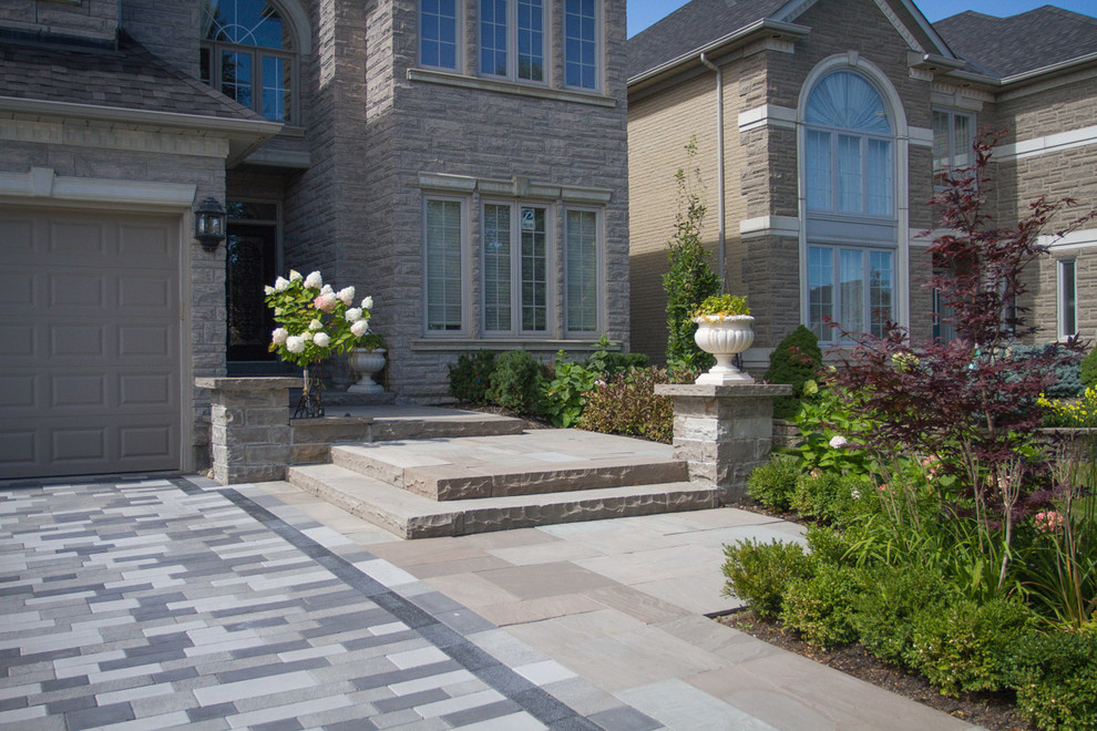 Inspiration for a mid-sized contemporary front yard full sun formal garden for summer in Toronto with a garden path and natural stone pavers.