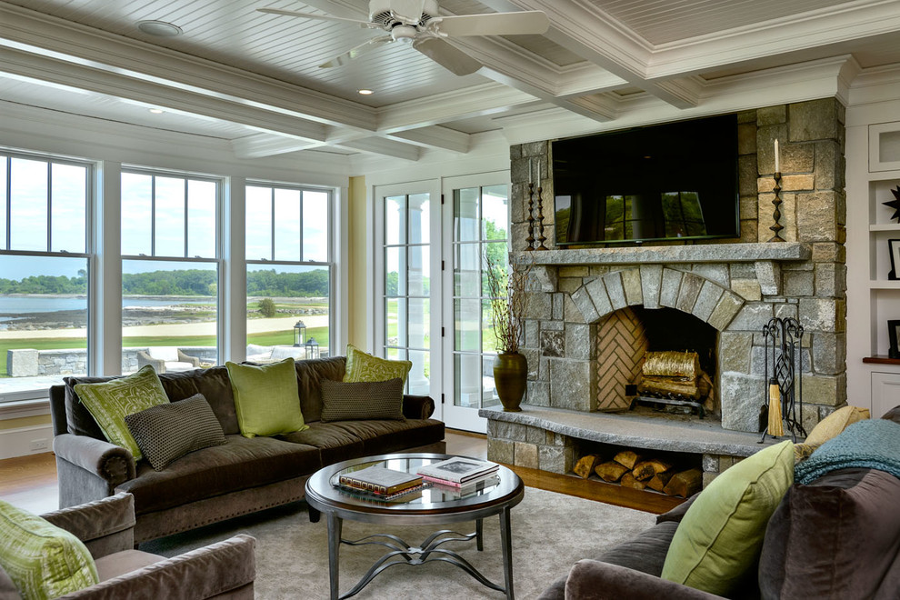 Inspiration for a mid-sized beach style formal open concept living room in Boston with yellow walls, medium hardwood floors, a standard fireplace, a stone fireplace surround and a wall-mounted tv.