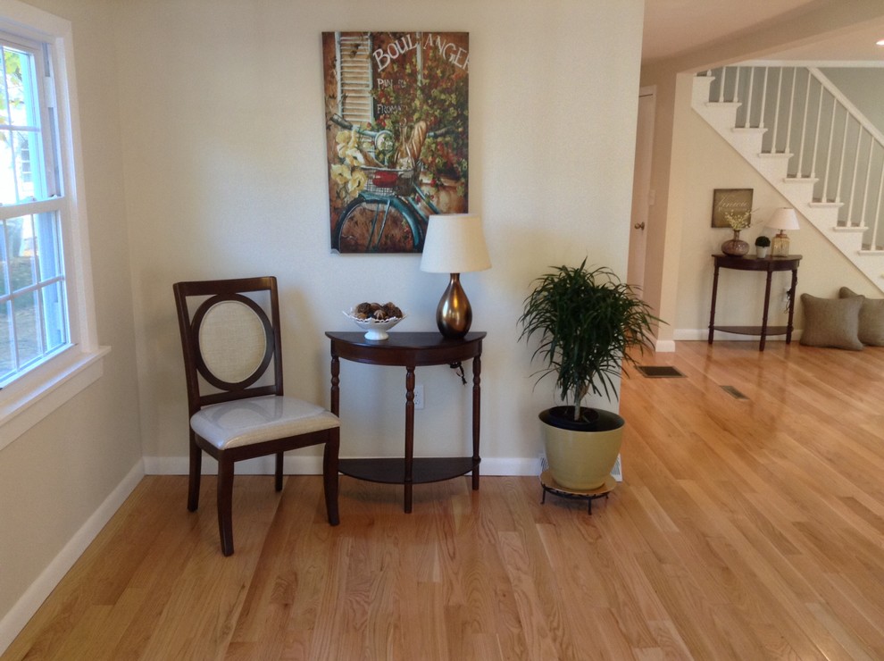 This is an example of a mid-sized eclectic entryway in Bridgeport with beige walls, light hardwood floors and beige floor.