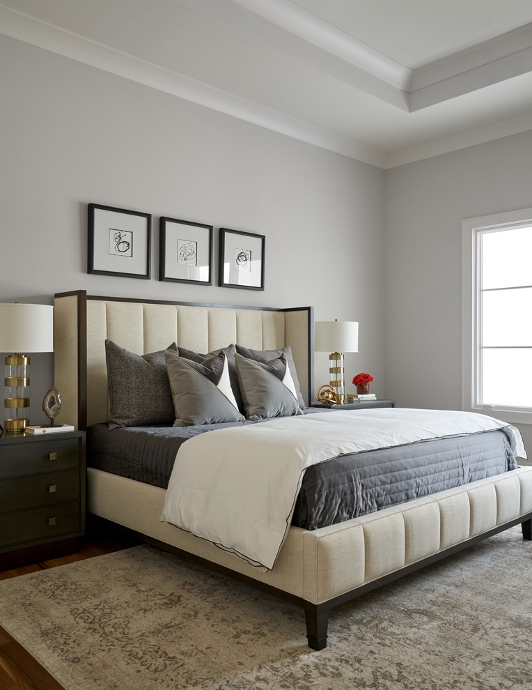 This is an example of a mid-sized transitional master bedroom in Dallas with white walls, medium hardwood floors and beige floor.
