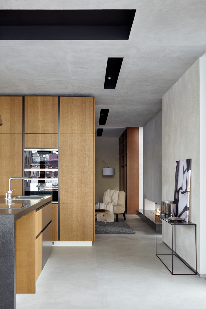 Imagen de comedor de cocina contemporáneo de tamaño medio con paredes grises, suelo de cemento y suelo gris
