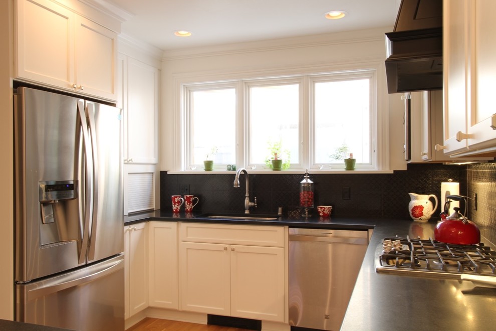Mid-sized transitional u-shaped eat-in kitchen in Milwaukee with an undermount sink, shaker cabinets, white cabinets, black splashback, stainless steel appliances, light hardwood floors, a peninsula, granite benchtops and ceramic splashback.