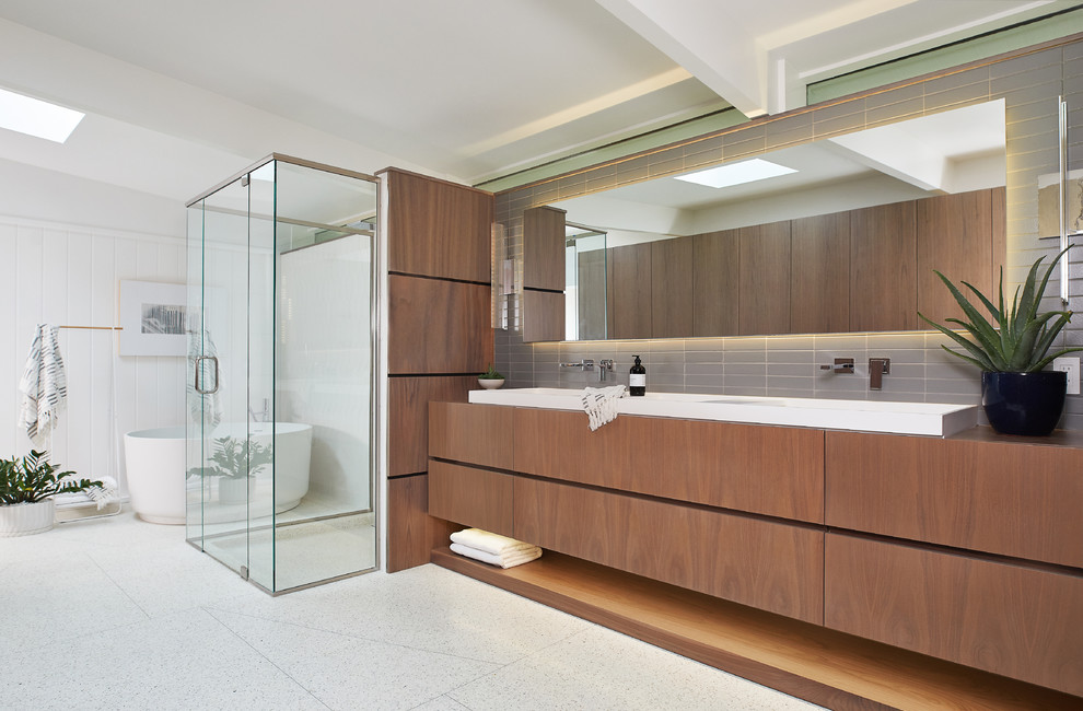 Inspiration for an expansive midcentury master bathroom in Grand Rapids with flat-panel cabinets, medium wood cabinets, a freestanding tub, a curbless shower, white walls, terrazzo floors, white floor and a hinged shower door.