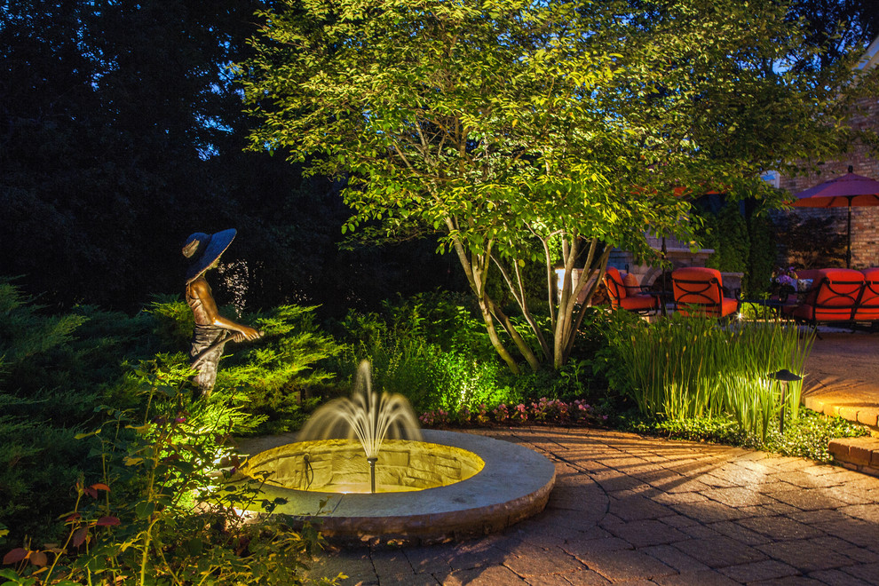 Inspiration for a traditional backyard garden in Chicago with a water feature.