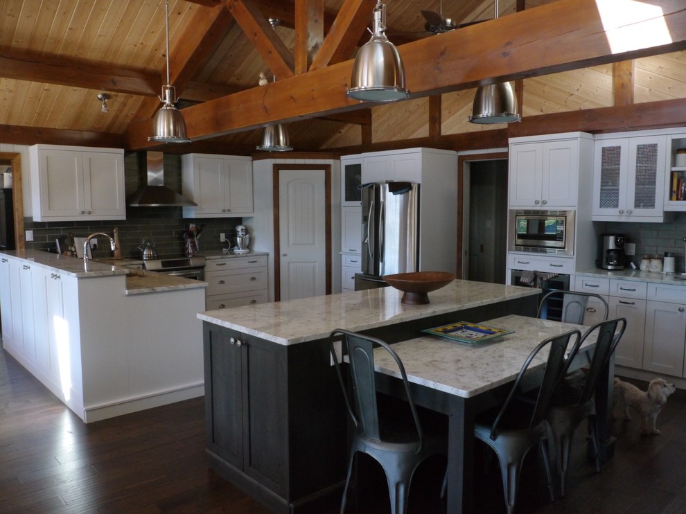 Eat-in kitchen - mid-sized u-shaped dark wood floor and brown floor eat-in kitchen idea with an undermount sink, recessed-panel cabinets, white cabinets, marble countertops, gray backsplash, subway tile backsplash, stainless steel appliances, an island and white countertops