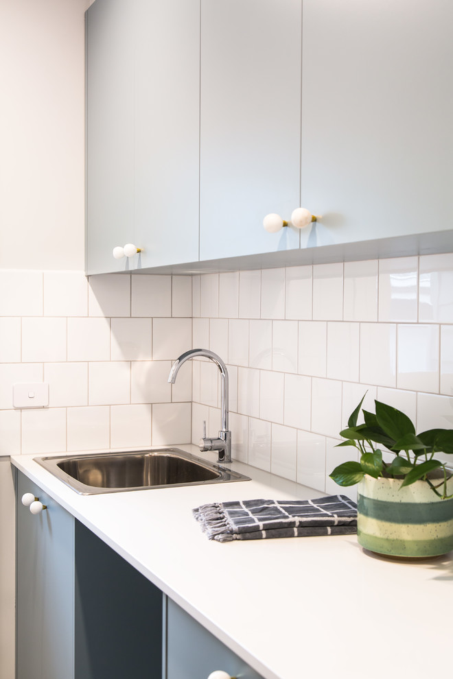 This is an example of a mid-sized modern single-wall kitchen in Melbourne with a drop-in sink, flat-panel cabinets, grey cabinets, quartz benchtops, porcelain floors, grey floor and white benchtop.