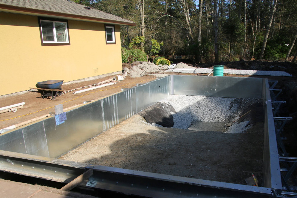 Inspiration för en stor funkis rektangulär pool på baksidan av huset, med marksten i betong