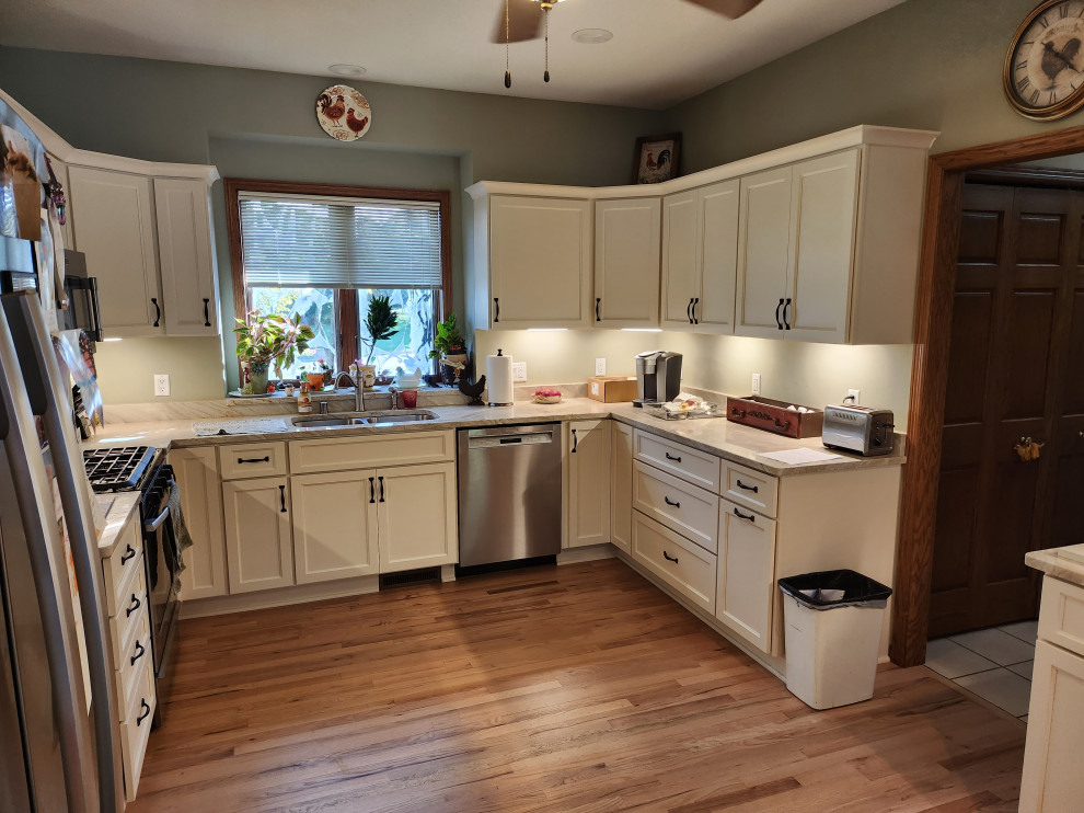 Inredning av ett modernt mellanstort kök, med luckor med upphöjd panel, vita skåp och en halv köksö