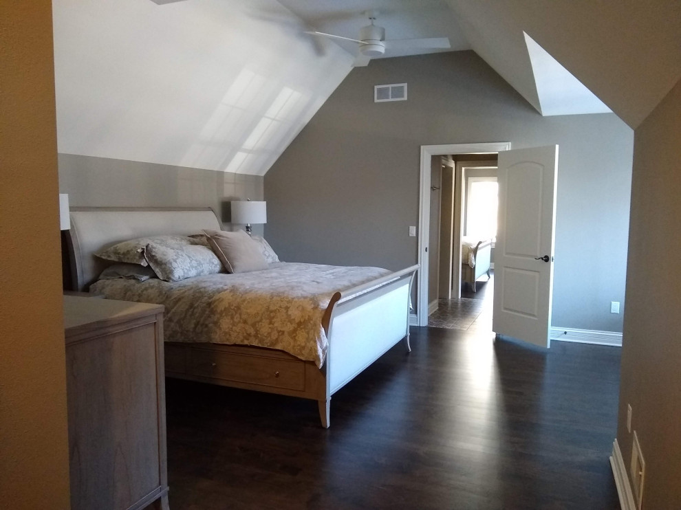 Cette photo montre une chambre d'amis chic de taille moyenne avec un mur marron, parquet foncé, aucune cheminée, un sol marron et un plafond voûté.