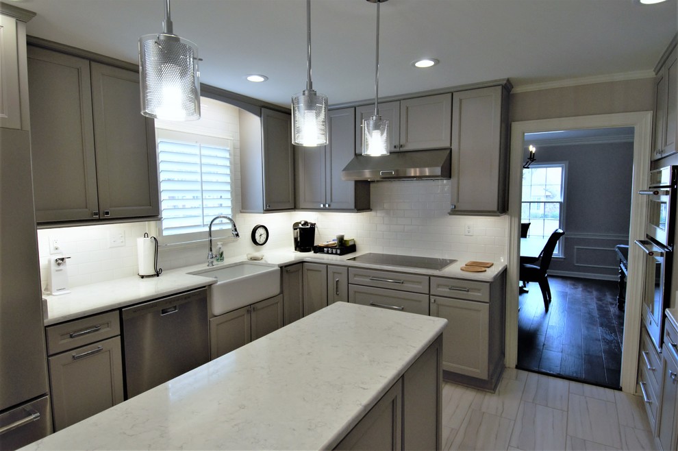 Example of a large transitional u-shaped porcelain tile and beige floor eat-in kitchen design with a farmhouse sink, recessed-panel cabinets, gray cabinets, granite countertops, white backsplash, subway tile backsplash, stainless steel appliances, an island and beige countertops